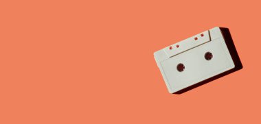 Turuncu arkaplanda izole edilmiş beyaz retro kaset