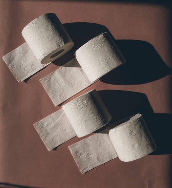 Tuvalet kağıtları pembe arka planda izole edilmiş.