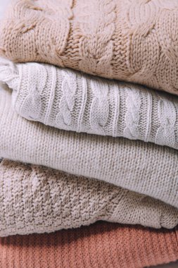 Beyaz arka planda örülmüş süveterler.