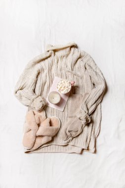 Açık arkaplan üzerine örülmüş atkı ve havlu örülmüş rahat beyaz battaniye..