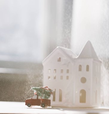 Evin arka planında Noel oyuncak arabası var. 