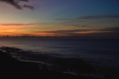 Okyanus dalgaları ve altın gökyüzüyle kumsalda güzel bir gün doğumu