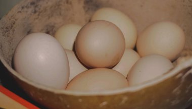 Kaptaki taze organik tavuk yumurtalarının yakın çekimi protein zengini bir kahvaltı için sağlıklı bir bileşeni temsil ediyor.
