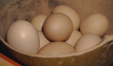 Kaptaki taze organik tavuk yumurtalarının yakın çekimi protein zengini bir kahvaltı için sağlıklı bir bileşeni temsil ediyor.