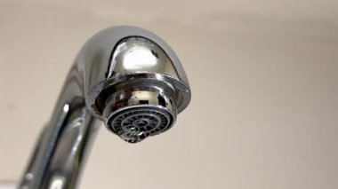 Musluktan Düşen Su Havalimanı. Düşen su damlası olan bir musluğa yakın çekim, su sızıntısı, atık, koruma, su tasarrufu, ev tesisat sorunu ve sürdürülebilirlik kavramı..