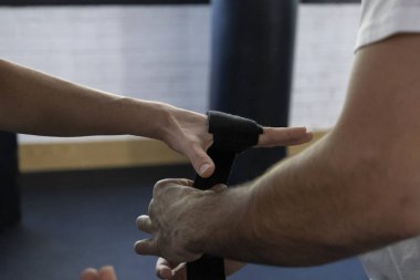 close-up of hands putting on boxing gloves