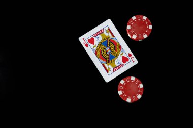 Siyah arka planda kırmızı kumarhane fişleriyle çevrili bir kupa valesinin üst görüntüsü. Kumar ve kumarhane konsepti güçlü bir kontrast ve kopyalama alanı ile.