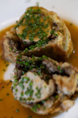 Bol soslu ve taze soğanlı dilimlenmiş sığır eti Wellington.