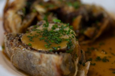 Soslu sığır eti ve beyaz tabakta doğranmış soğan.