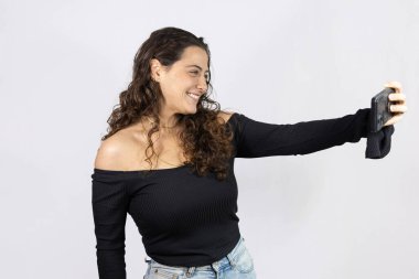 Gülümseyen ve elinde akıllı telefon tutan bir kadın.