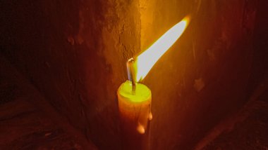 Elektrik kesintisi nedeniyle karanlık bir odada yanan bir mum..