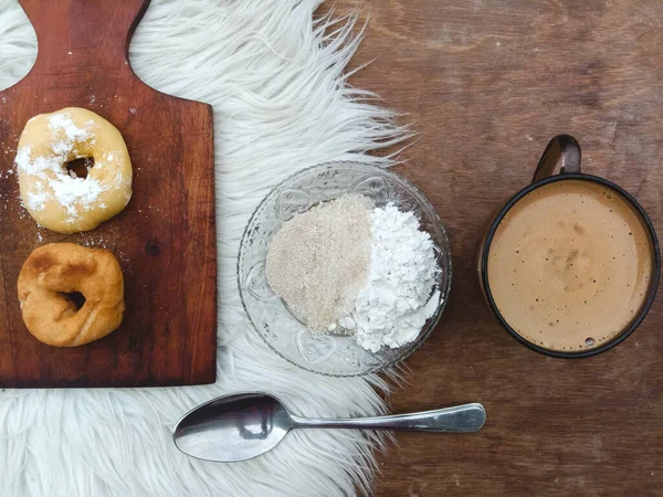 Çörekler ve çeşitli malzemeler, masada sıcak beyaz kahve, yiyecek ve içecek teması.