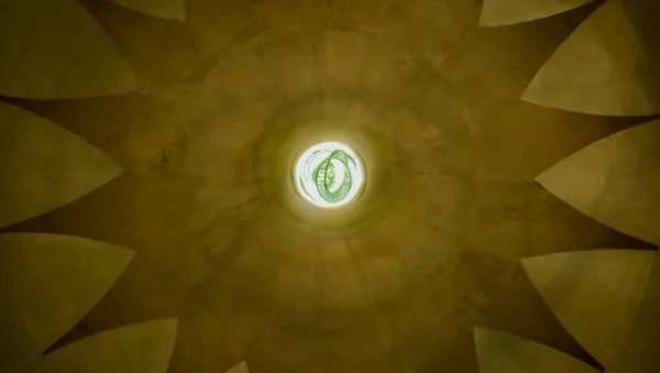 Ortasında halka şeklinde bir lamba olan cami binasının tavanının altındaki manzara, bina ve dinin teması.