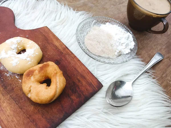 Pişmiş ve çiğ çörekler. İçindekilerin bir kısmı cam tabakta ve bir fincan sıcak beyaz kahveyle..