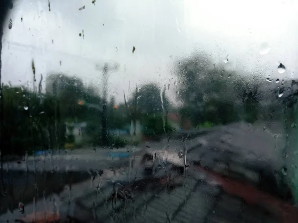 Yağmurlu bir günde çiğ ve su damlacıkları olan yatak odası penceresi..