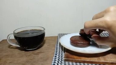 Çikolatalı turtayı alıp kameraya gösteren kişinin el kamerasıyla çekilmiş fotoğrafı..