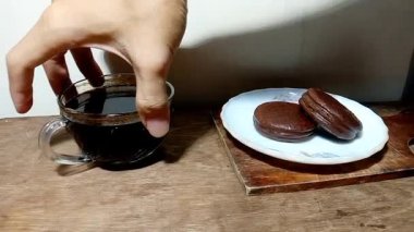 Tahta masa boşalana kadar tatlıyı ve kahveyi çerçeveden çıkartırken çekilen statik görüntüler..