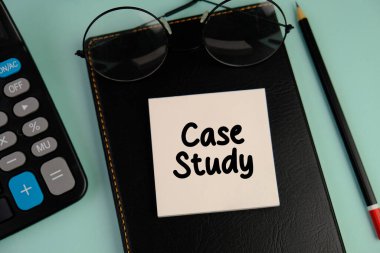 Hesap makinesi ve kırtasiyenin yanındaki beyaz not defterindeki bir iş için CASE Study 'ye mesaj at. İş konsepti.