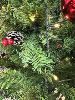 Sezonun selamlama sahnesi. Noel süslemeleri, balolar, kır yıldızları, kutsal meyveler, buzlu ladin dalları yeşil arka planda konfeti, mesajlar ve tanıtım için mükemmel. metin alanı kavramı