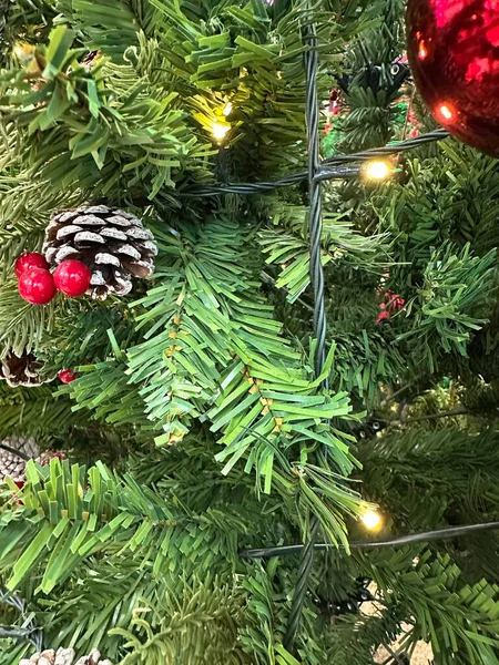 Sezonun selamlama sahnesi. Noel süslemeleri, balolar, kır yıldızları, kutsal meyveler, buzlu ladin dalları yeşil arka planda konfeti, mesajlar ve tanıtım için mükemmel. metin alanı kavramı