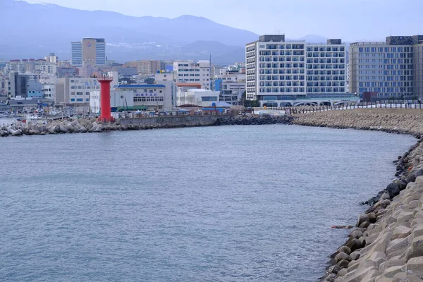 Jeju, Güney Kore - 11 Şubat 2026: Gün batımındaki Jeju cazibesi. Deniz feneri yakındaki beton kuleler
