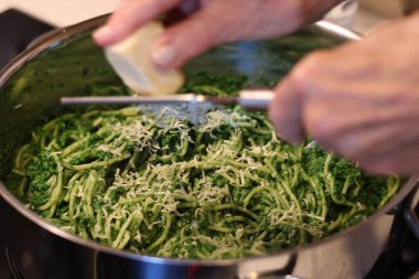 Makarnayı ıspanak, fesleğen, yeşil bezelye ve yeşil maydanozdan pesto ile hazırlama süreci: makarna ile pesto 'yu tencerede birleştirme.