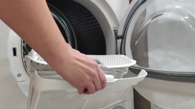 Kadın kurutma makinesinin filtresini temizliyor. Yüksek kalite 4k görüntü