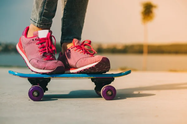 Meisje staat op skateboard — Stockfoto