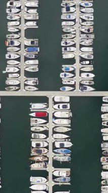 Yat limanının yukarıdan görünüşü. Beyaz tekne ve yatlar koyu yeşil sularda demirli. Denizcilik organizasyonunu gösteriyor.