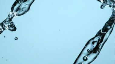 Dinamik su, yüksek hızlı ağır çekimde, sıvı fizik hareketini vurgulayan açık mavi bir zemine karşı havada birbirine çarpar.