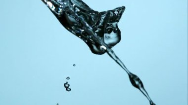 İki kristal berrak su akıntısı havada sıçrıyor ve birleşiyor. Yüksek hızlı ağır çekimde açık mavi bir arka planda.