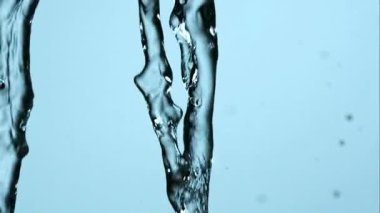 Birkaç akarsu akıntısı, açık mavi arkaplan üzerinde ağır sıçramalarla ve yüksek hızda hareket yakalama ile birleşiyor.