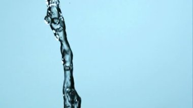 Temiz suyun dinamik akışı açık mavi bir zemine doğru sıçrıyor ve kıvrılıyor, görünür damlacıklar ve güzel akışkan hareketlerle ağır çekimde.