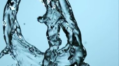 Çok sayıda taze, berrak su akıntısı serpiliyor ve birbirine karışıyor yumuşak, mavi bir zemin üzerinde güzel sıvı hareketler ve yavaş çekimde damlacıklar var.
