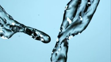 Temiz doğa konsepti için açık mavi bir arka planda kristal berrak temiz suyun yüksek hızda fotoğraflanması ve havada sıçraması.