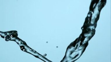 Temiz hidrasyon kavramları için yavaş çekimde açık mavi bir arkaplan üzerine akan ve birbirine sıçrayan ferahlatıcı iki su akıntısı.