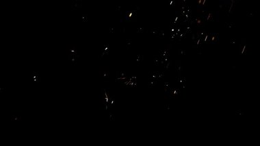 Parlak turuncu kıvılcımlar ve havada uçuşan sıcak metal közleri dramatik bir ağır çekim görüntüsüyle siyah bir zemin üzerinde.