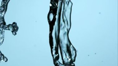 Arkaplan kullanımı için sanatsal sıvı hareketi ve şeffaflığı olan açık mavi bir zemin üzerinde akan ve birleşen temiz su akışlarının güzel yavaş çekim görüntüleri
