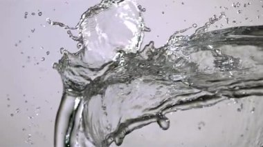 Temiz su, hafif bir zemine doğru yavaşça hareket ediyor. Güzel sıvı şekiller ve küçük damlacıklar yaratıyor.