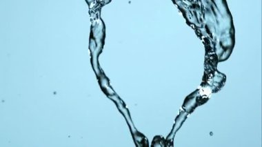 Birden fazla berrak su akışının sinematik yavaş çekim görüntüsü birleşerek mavi arkaplana karşı soyut bir sıvı desen oluşturmak için girdap oluşturur.