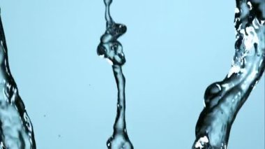 Pürüzsüz kristal berrak su, parlak açık mavi bir arkaplana karşı sanatsal sıvı hareketle birden fazla ağır akışında akıyor.