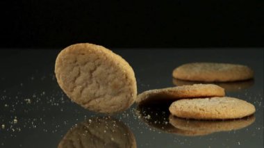 Yuvarlak Şekerli Kurabiyeler Düşüyor ve Zıplıyor Kırıntılar ve Yavaş Çekimde Siyah Arkaplan Karşısındaki Profesyonel Stüdyo Işığıyla Karanlık Yansıtıcı Yüzeyde