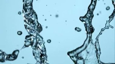 Makro yüksek hızda temiz su sıçrıyor ve parlak mavi bir zemine çarpıyor güzel sıvı şekiller ve hareket halindeki damlacıklar yaratıyor.