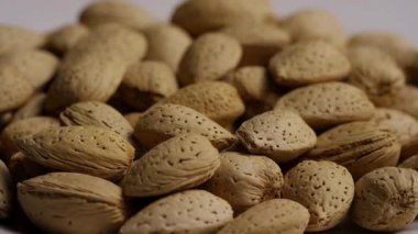 Kabuklu organik badem yığınının dokusunu ve sağlıklı protein zengini abur cuburların bolluğunu göstermek için yavaşça dönen görüntüsünü kapat.