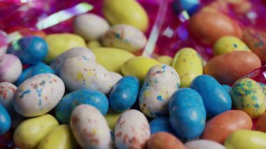 Canlı pastel renkli şeker yumurtaları ve jelibonlar neşeli bir Paskalya tatili atmosferi için parlak pembe şeritlerle dönüyor.
