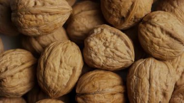 Sağlıklı beslenme ve gıda dokusu geçmişi için çerçeveyi dolduran kahverengi kabuklu cevizlerden oluşan tepeden tırnağa dönen bir kare.