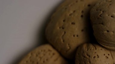 Sert badem kabuklarının üzerinde detaylı çukurlar ve doğal kahverengi ahşap dokular gösteren aşırı makro izleme görüntüleri.