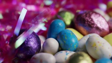 Pembe Paskalya otunda Benekli Şeker Yumurtaları ve Folyo Çikolatalı Yumurtaların Yakın Çekim Çekimi