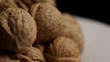 Tüm doğal cevizlerin desenli kabuklarına odaklanarak sağlıklı yiyecek kavramı için bir yığın halinde dönen kamerayı kapat.