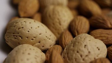 Doğal dokuları ve hafif ışıklandırmayı gösteren kabuklu organik bademlerin makro çekimi.